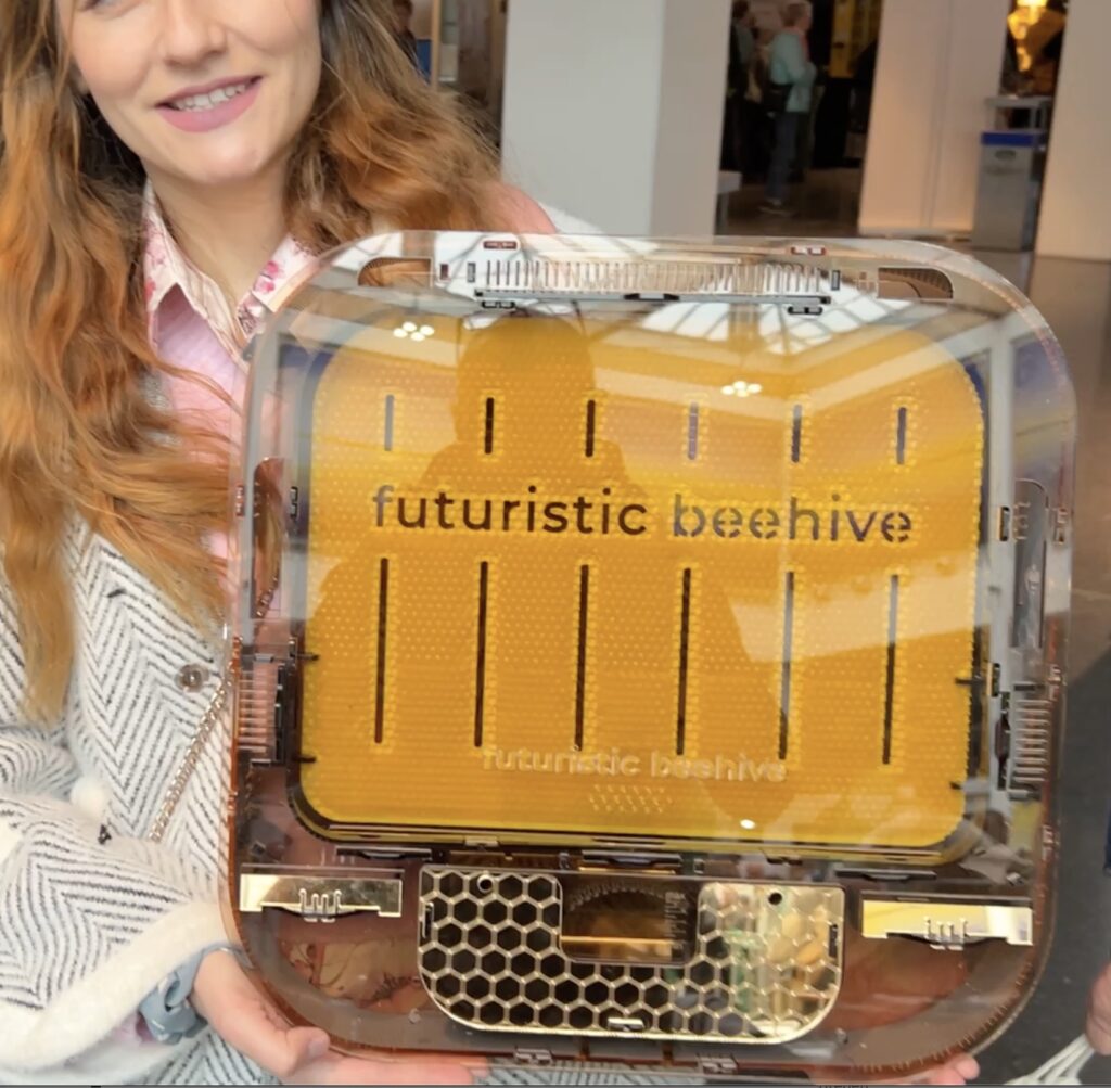 Im Interview auf der eurobee 2025 - zwei junge Leute mit dem "Futurist beehive" einer Bienenbeute für das Wohnzimmer.